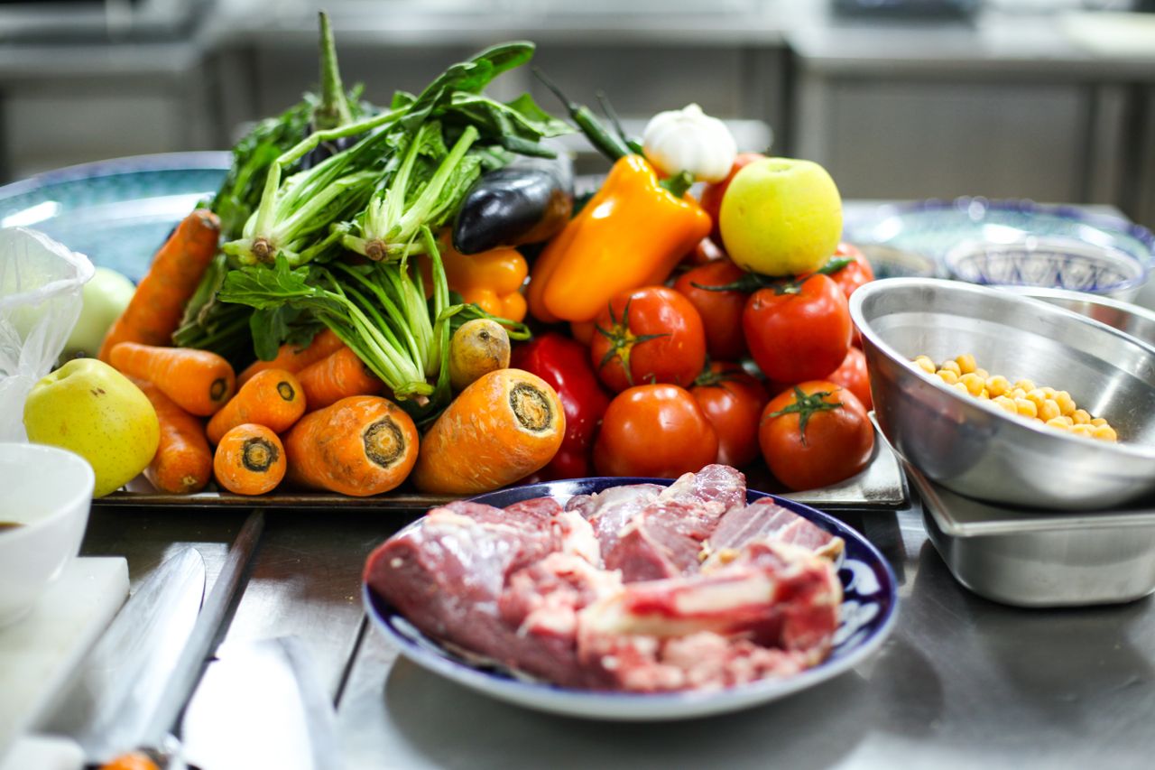 our-services-1 Vibrant assortment of fresh vegetables and meat on a kitchen counter for cooking inspiration.