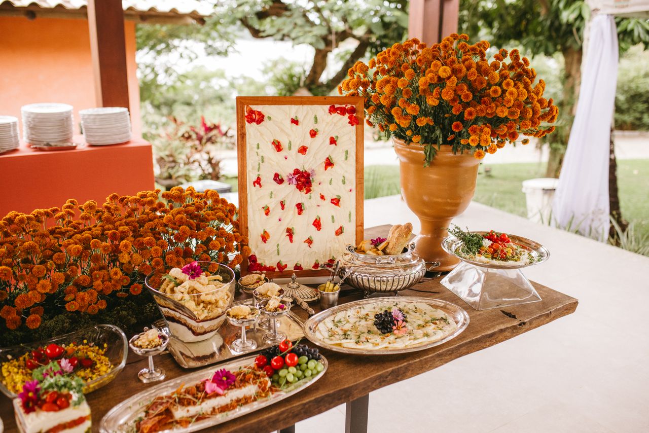 about-img Wedding buffet setup with vibrant floral decor and diverse dishes, perfect for outdoor events.