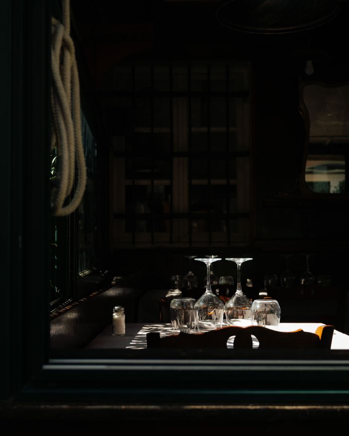 services-01 Cozy indoor dining setup with sunlight on glasses, creating a warm ambiance.